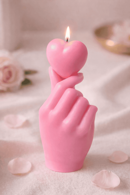 Handgegossene Skulpturkerze „Getragenes Herz“ aus rosa Sojawachs – Hand hält ein Herz, liebevoll inszeniert