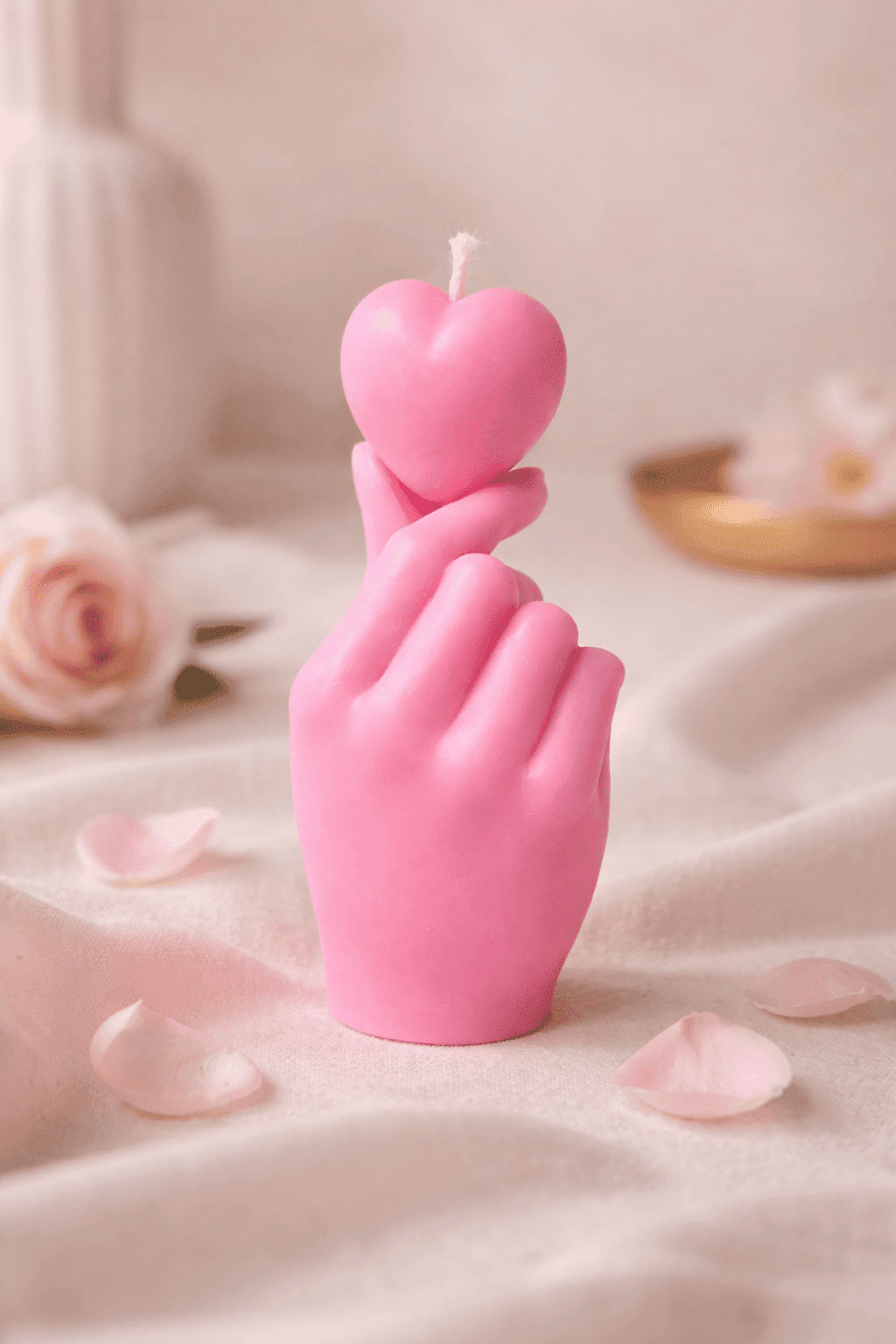 Handgegossene Skulpturkerze „Getragenes Herz“ aus rosa Sojawachs – Hand hält ein Herz, liebevoll inszeniert